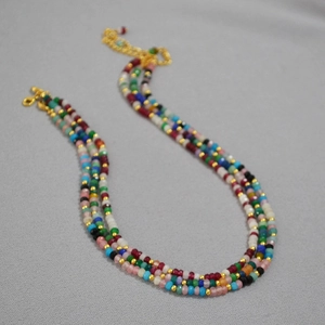 Close-up of triple-strand colorful beaded bohemian necklace with golden lobster clasp