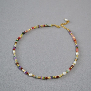 Dettaglio di una collana con perle colorate e perle d'acqua dolce con chiusura a moschettone