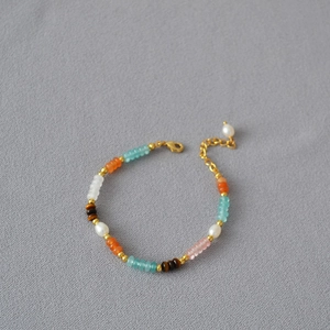 Detail of colorful gemstone beaded necklace with freshwater pearls and gold lobster clasp