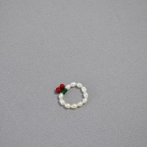Detail shot of freshwater pearl elastic ring featuring a cute red cherry design decoration