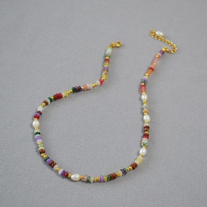 Dettaglio di collana boho con pietre naturali colorate e perle d'acqua dolce
