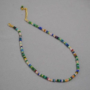 Macro detail of Bohemian colorful beaded necklace with faceted stones and golden spacer beads