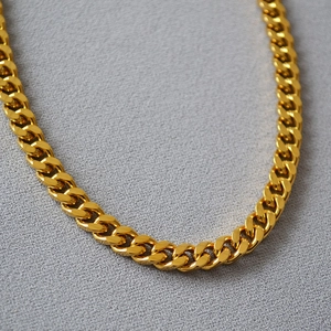 Detail of chunky gold-plated stainless steel Cuban link chain with high-shine finish