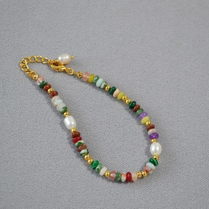 Dettaglio di una collana con perline colorate, perle d'acqua dolce e gancio oro
