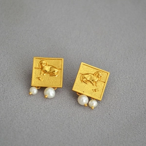Détails des boucles d'oreilles vintage dorées avec relief animalier et perles