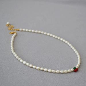 Détail du collier de perles d'eau douce avec cerises rouges et fermoir doré