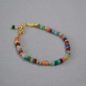Détail d'un bracelet de perles d'agate colorées à facettes avec fermoir mousqueton doré