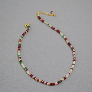 Detail of colorful bohemian beaded necklace with gold spacers and adjustable lobster clasp