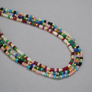 Close-up of colorful 2mm beads and gold spacer beads in a bohemian layered necklace