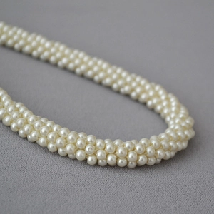 Détail macro du collier multi-rangs en perles de verre tissées main pour la soirée