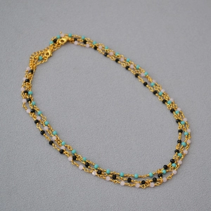 Detailed view of triple-layered gold choker with turquoise, black and pink beads