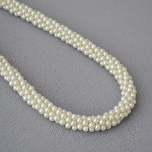 Vue détaillée du collier de perles multicouches tissé à la main, éclat crème