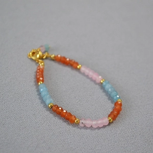 Gros plan d'un bracelet en perles arc-en-ciel avec pierres d'agate et billes dorées