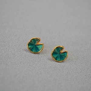 Macro detail of vivid green enamel lotus leaf earrings with golden texture edges