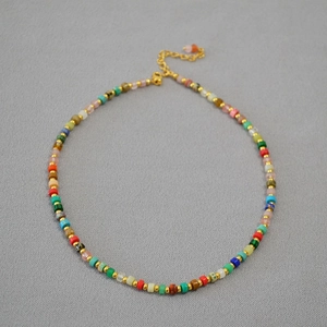 Detail of colorful stone beads necklace with gold spacers and lobster clasp closure