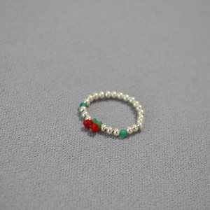 Minimalist handmade beaded ring featuring silver beads and a red cherry design charm