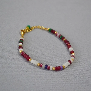 Gros plan d'un bracelet en pierres colorées avec une chaîne d'extension dorée réglable