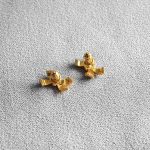 Elegant gold bow earrings with white enamel finish shown from a 45-degree back angle view