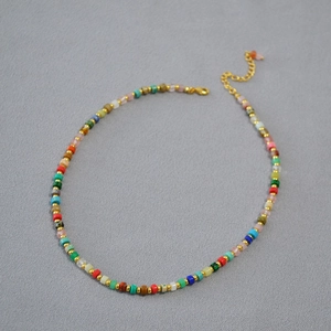 Detail of colorful stone beads necklace with gold metal spacers and lobster clasp