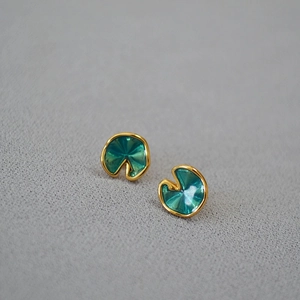 Detailed macro view of green enamel lotus leaf earrings with golden metal edges
