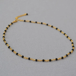 Detail of hand-woven black spinel choker with gold wire and lobster clasp adjustment
