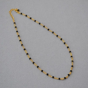 Detail view of the black spinel beaded choker necklace with golden wire weave and lobster clasp