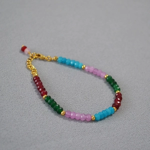 Détail de perles facettées colorées avec séparateurs dorés et fermoir mousqueton réglable