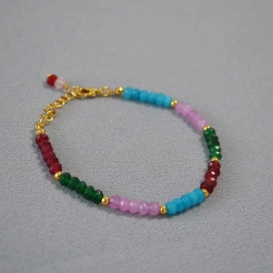Détail d'un bracelet en perles facettées colorées avec fermoir doré réglable