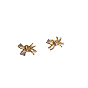 Sweet white enamel bow stud earrings with vintage gold beaded edges on white background