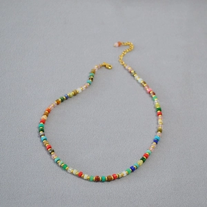 Detail of colorful stone beads necklace with gold spacers and lobster clasp closure