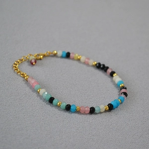 Détail d'un bracelet en perles d'agate multicolores avec fermoir mousqueton doré et extension
