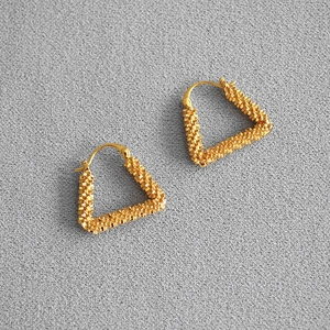 Golden geometric triangular hoop earrings with sparkling frosted texture and snap closure