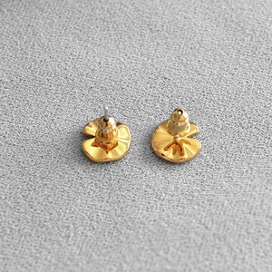 Detail view of golden irregular curved petal earrings with secure metal bullet backings