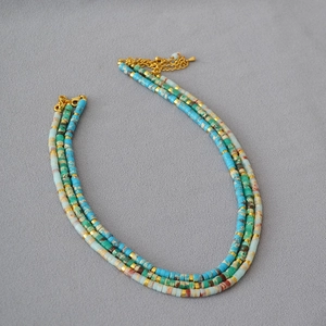 Detail of multi-layer ocean style stone bead necklace with golden spacers and lobster clasp