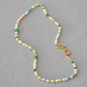 Detailed close-up of a multi-color pearl necklace with a vintage gold OT toggle clasp