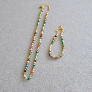 Detail of colorful stone beads and golden metallic accents in a beaded jewelry set