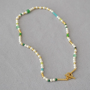 Detail of freshwater pearl necklace with colorful beads and golden toggle clasp