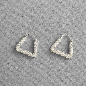 Modern silver triangular hoop earrings with unique shimmering granulated texture