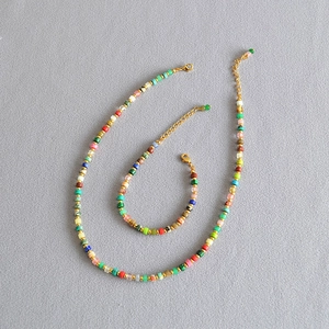 Detail showing colorful stone beads and golden spacer accents on necklace and bracelet