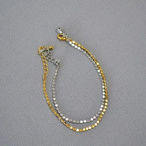 Detail of minimalist gold and silver disc chains with lobster clasp and extension