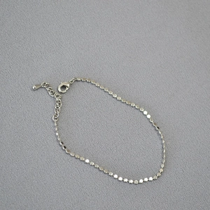 Minimalist silver chain bracelet with shiny flat metal discs and adjustable lobster clasp