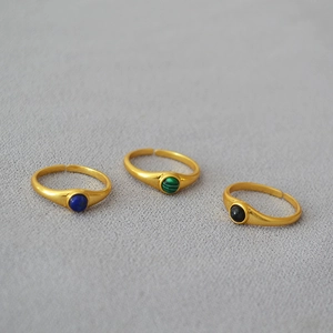 Detail of adjustable open rings featuring matte gold finish and inlaid natural stones