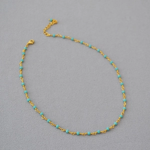 Detailed view of woven black spinel choker with gold link chain and lobster clasp