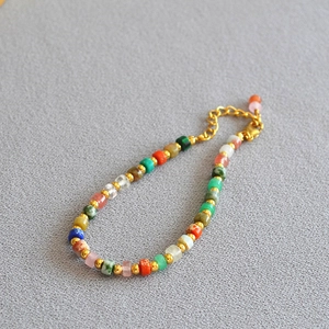 Colorful natural stone bead necklace with golden accents and adjustable chain extension
