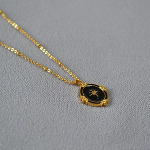 Detail of French vintage gold satellite chain and black enamel oval star pendant