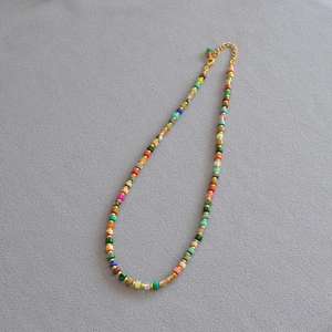 Detail of colorful stone beads and golden spacer beads on a bohemian style necklace
