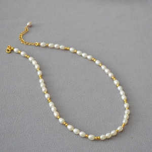 Collier de perles d'eau douce de style français avec perles dorées sur tissu gris