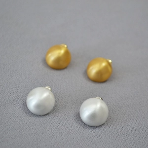 Minimalist matte gold and silver dome stud earrings with brushed metallic texture