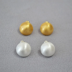 Close-up of matte brushed hemisphere earrings in gold and silver finish 925 silver needle