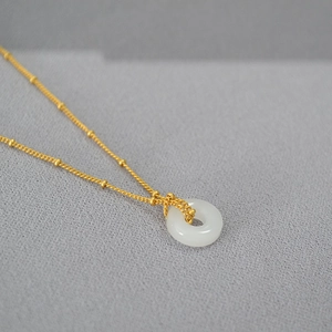 Macro de pendentif en jade blanc sur chaîne à billes dorée de style minimaliste